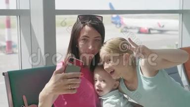 家人在等待飞机时用智能<strong>手机</strong>自拍。 家人在<strong>国际</strong>机场等候航班